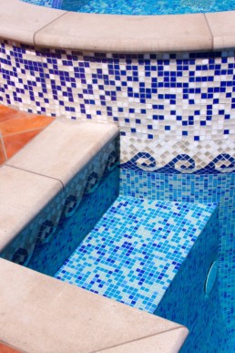 Mexican Hacienda feel created with the rose toned and jeweled blue custom laid and hand crafted mosaic patterned tile that lines the whirlpool walls with a vibrant blue mosaic tiled floor in the adjacent swimming pool