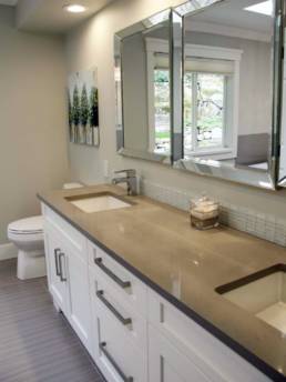 modern bathroom with beveled mirrors, silestone quartz countertops and white glass tile brick mosaic back-splash