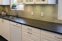 white cabinets for a fresh feel complement the earthy tones of the countertops and back-splash