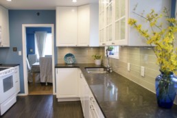 cheerful blue and white kitchen with rich brown floors and countertops