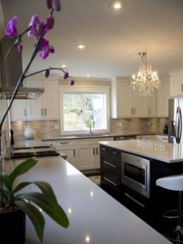 white shaker cabinets with glass mosaic tiled walls in a cream toned kitchen