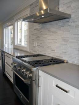 grey and white kitchen backsplash done in glass mosaic tile