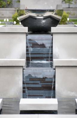 Silver fire bowl on top of a stunning tiered water feature.