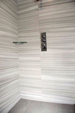 funky modern shower with a striped tile in neutral tones