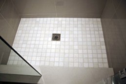 porcelain tile shower file in an off-white 2x2 tile that mimics marble