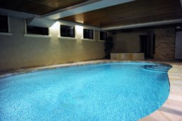 Vibrant blue mosaic glass tile sends an ethereal glow when the pool light is one at night time.
