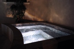 Night time view of a glass tiled whirlpool.